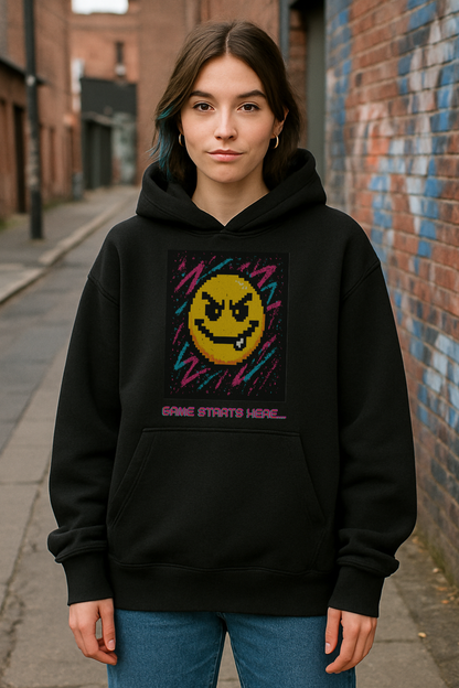 Person wearing a black hoodie with a colorful smiley face design on a street.